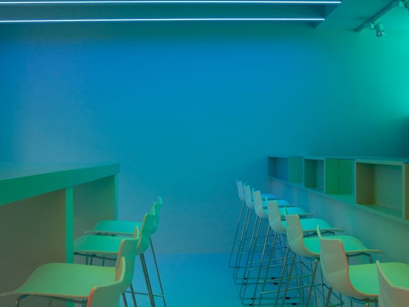 Wide shot of a clean minimal exercise space with neon light.